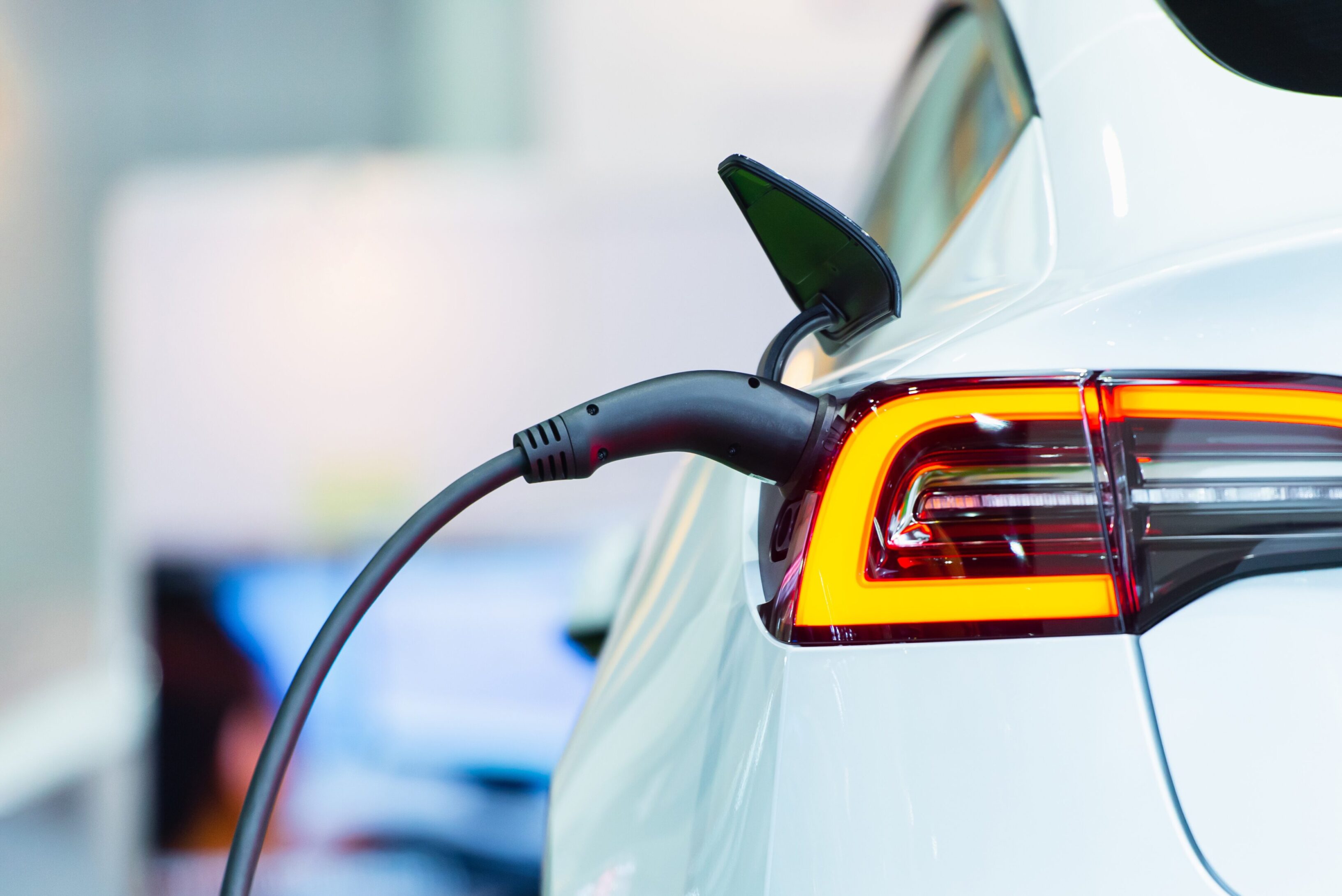 A close up of the side of a car with an electric vehicle charging.