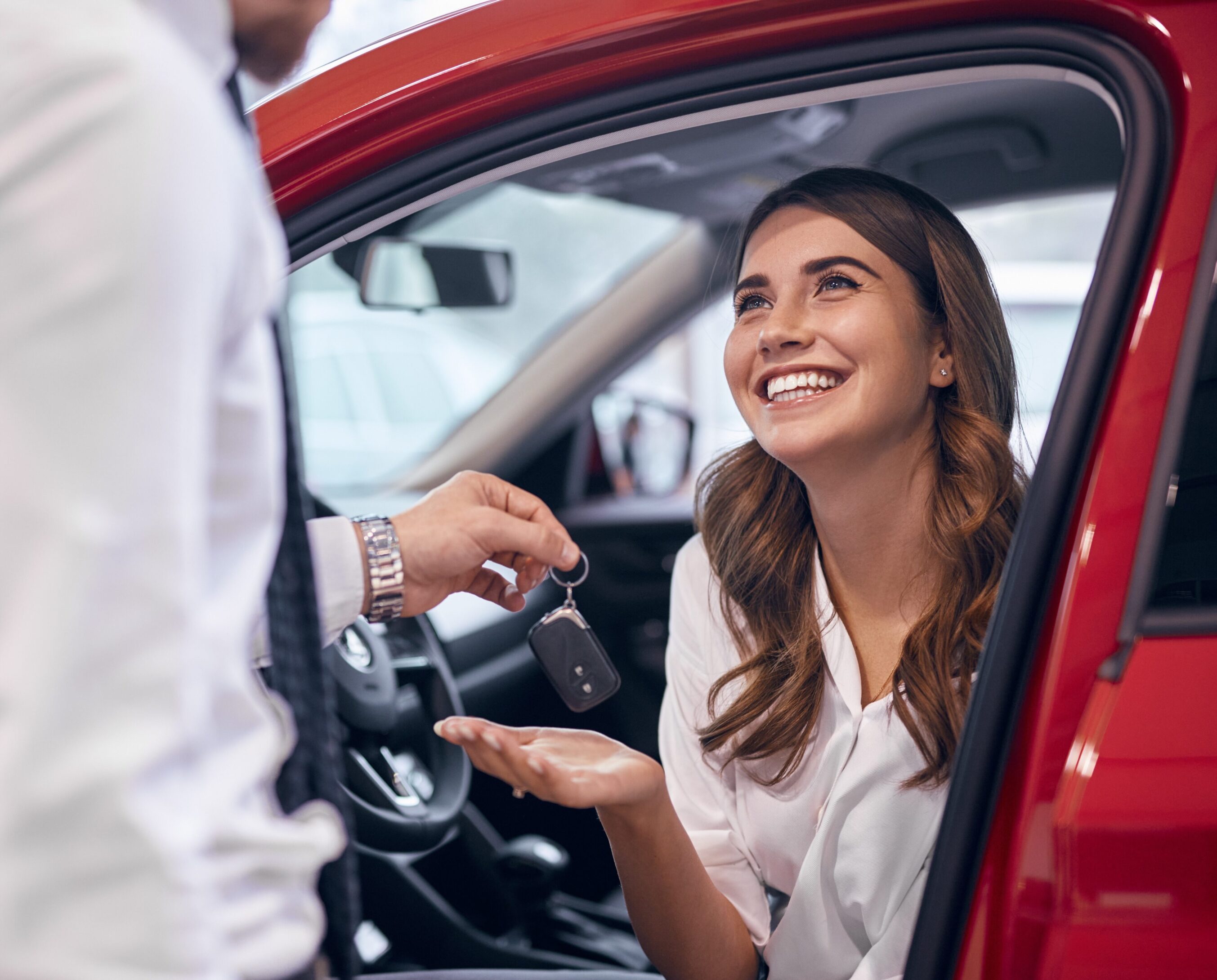 A woman sitting in the driver 's seat of a car.