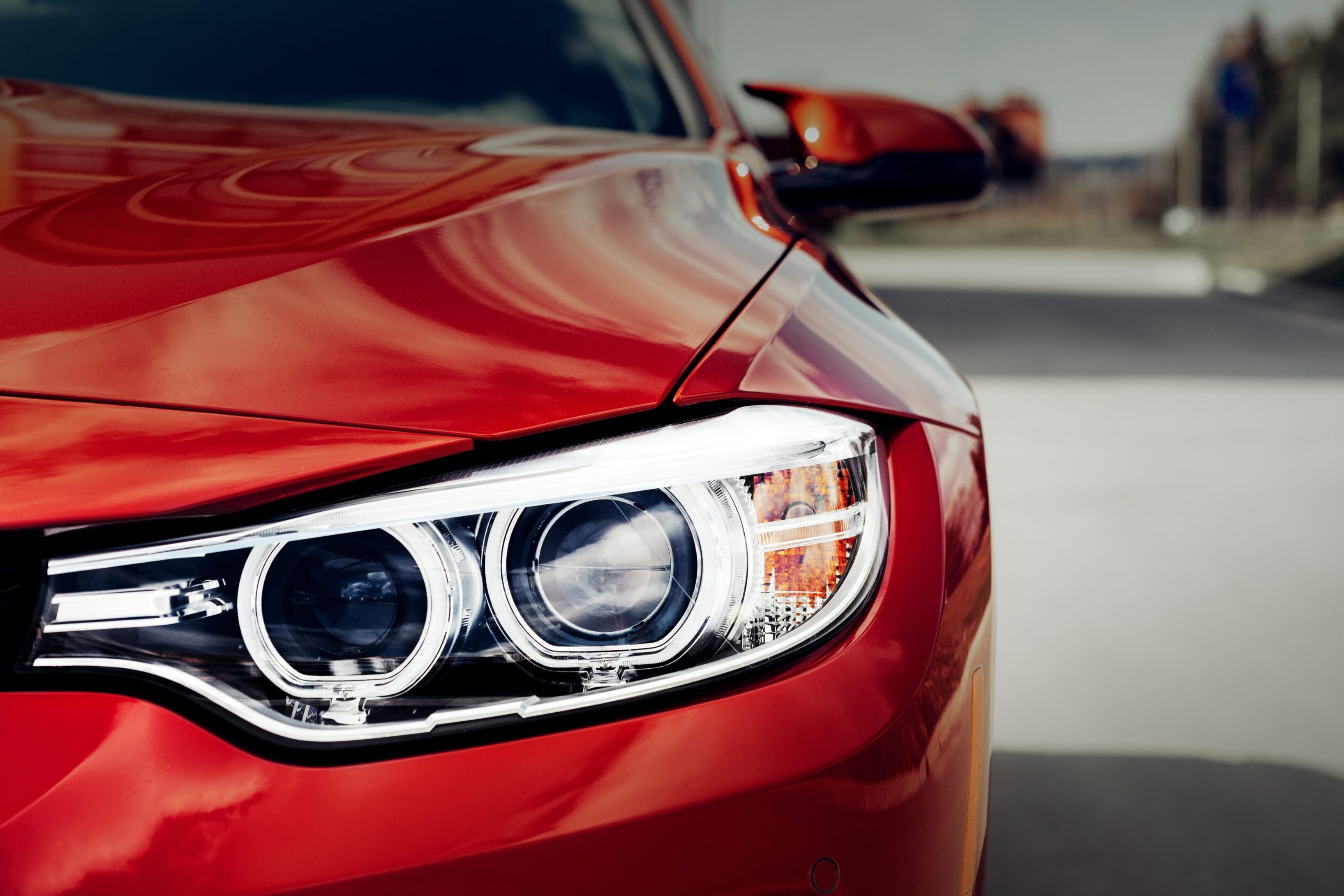 A close up of the headlight on a red car